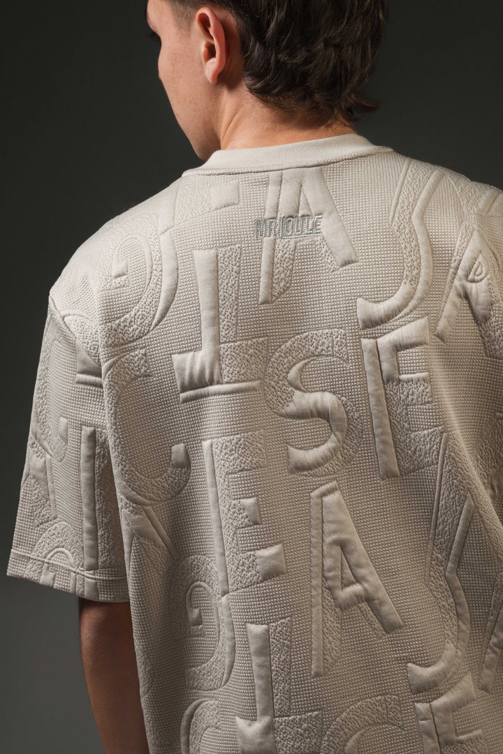 Camiseta con tela textura, diseño de letras y logo bordado en Espalda
